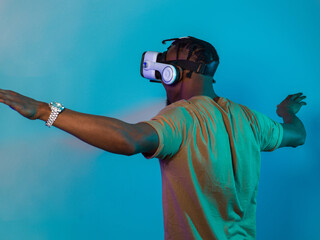 African American man dons VR glasses, engrossed in a virtual reality simulation, gesturing with...