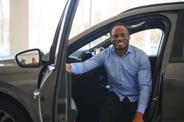 Happy Car Buyer, New Car Owner Concept. Portrait Of Excited Young African American Guy In Dealership Showroom