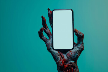 Creepy halloween monster zombie hand holding a mobile phone with a blank screen - obrazy, fototapety, plakaty