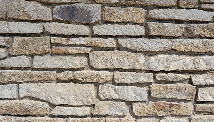 wall of stones as a texture for background; gray beige stone bricks close-up