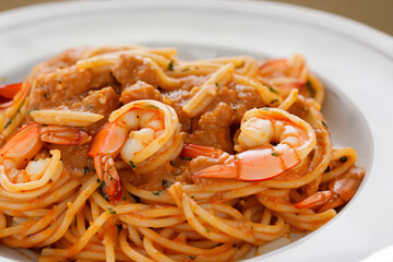 pasta with shrimp. Spaghetti with gravy and small shrimps lie on a white plate close-up, bulk food concept