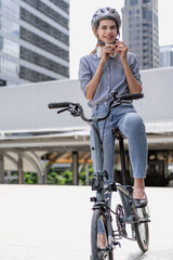 Fototapeta na wymiar Confident businesswoman ride bicycle outside in downtown. Environmental conservation person commuting by cycling reduce carbon footprint. Bile to work, eco friendly alternative vehicle to green energy