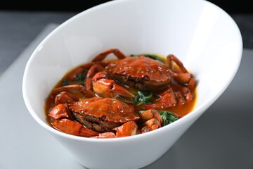 Delicious boiled crabs with sauce on table, closeup