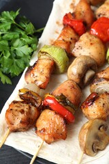 Delicious shish kebabs with vegetables on table, closeup
