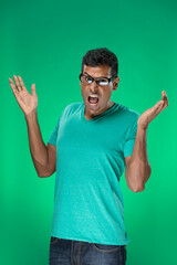 Fototapeta premium Surprised Indian man standing against green background.