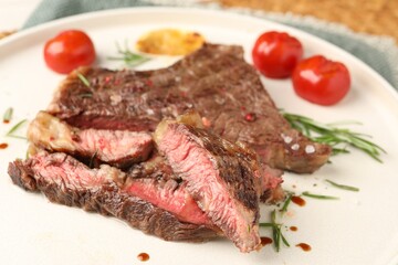 Delicious grilled beef steak, tomatoes and rosemary on plate, closeup