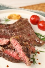 Delicious grilled beef steak, tomatoes and rosemary on plate, closeup