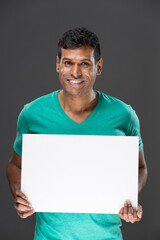 Indian man holding up a banner.