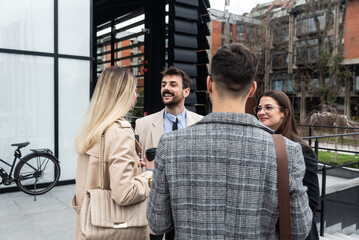 Fototapeta premium Group of young business people, job candidates standing in front of the office building waiting to be called to meeting with the employer. Businessmen and businesswomen waiting for human resources
