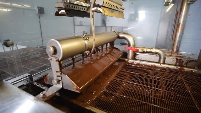 Conveyor with liquid chocolate. Confectionery factory. Chocolate factory. Candy production.