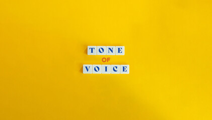 Tone of Voice Phrase in Branding. Text on Block Letter Tiles on Yellow Orange Background. Minimalist Aesthetic.