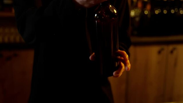 Pouring Wine into Measuring Jigger. Bartender pouring a stream of red wine into a jigger over a bar counter