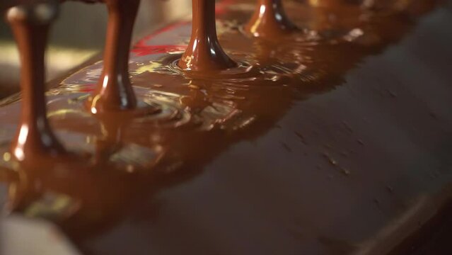 Conveyor with liquid chocolate. Confectionery factory. Chocolate factory. Candy production.