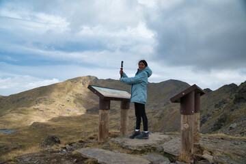 Girl hiker recording a video in Tristaina viewpoint in andorra, in high mountain in the andorran...