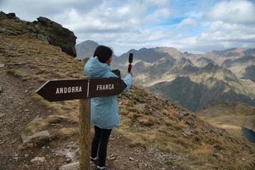 Girl hiker recording a video in Tristaina viewpoint in andorra, in high mountain in the andorran...