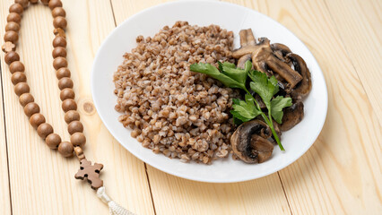 Buckwheat and prayer beads on a wooden table during Lent, Lenten food during the Great Orthodox Lent