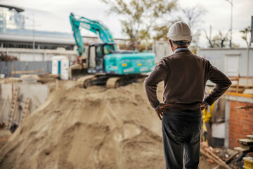 A senior site manager is looking at construction works on site.