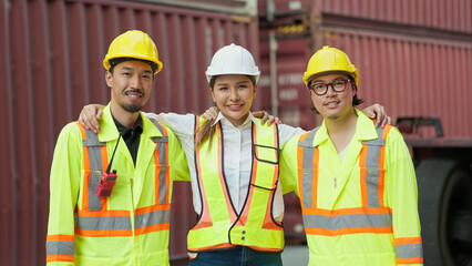 Group of asian engineers and workers wearing safety vests uniform and helmets standing with arm around shoulder and looking at camera. Logistic distribution, Teamwork concept