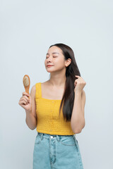 Photo portrait brunette woman showing wooden brush smiling isolated white color background