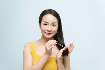 Woman using cosmetics for hair care on white background - 718898928