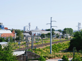 A train railroad gracefully makes its way along the train tracks beside a vibrant and lush green field from Strabourg, France to Kehl, Germany