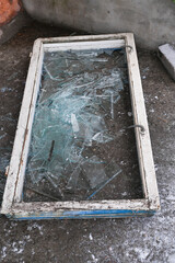 Broken glass on the floor. a broken old window.