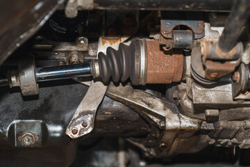 A close-up image of a car's half-shaft on the chassis, showing signs of age and rust.
