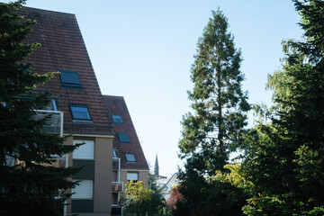 A building with a vibrant red roof standing amidst a lush landscape of trees.