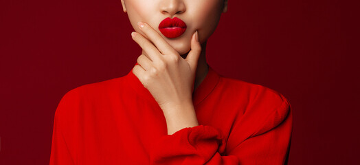 Matte lipstick. Blowing kiss. Fashion portrait of young asian model with lips make up posing with a chin look against red background. - obrazy, fototapety, plakaty