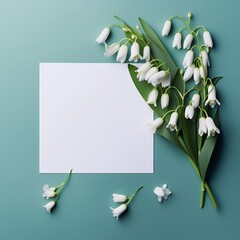 flowers of snowdrop bouquets on a blue background with a blank white piece of paper. frame with copy space