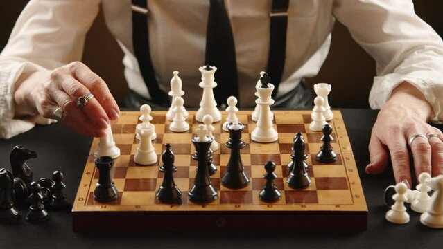Close-up of a chessboard during a tense game, a confident hand making a decisive move with a white knight. Many white and black pieces are scattered around the board, indicating an intense game.