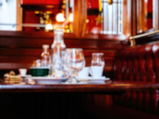 A defocused blur view of a cafe pub table with multiple glasses and bottles, capturing the casual and social ambiance of the setting