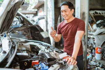young male mechanic finds a solution to fixing machines in the workshop