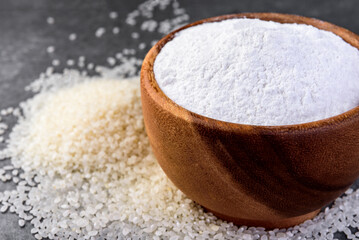 Rice flour in wooden bowl on gray background.