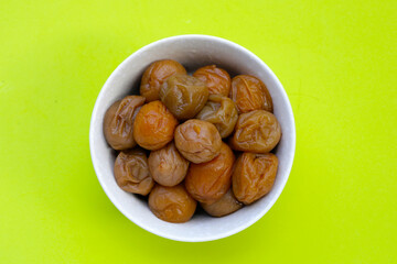 Pickled plums on green background.
