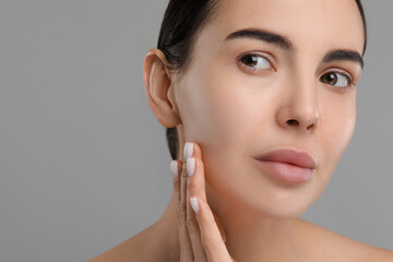 Young woman with dry skin on gray background, closeup. Space for text