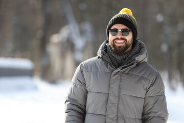 Fototapeta na wymiar Portrait of handsome young man with sunglasses on winter day outdoors
