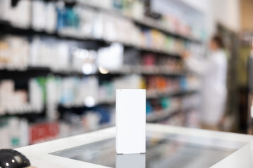 In pharmacy's sales area, there is box with therapeutic cream on separate display counter. Promotional product, regular customer discount. Apothecary unfocused in background