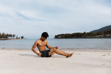 Fototapeta na wymiar Active Asian Man Running on Beach, Exuding Strength and Freedom in Outdoor Fitness Training
