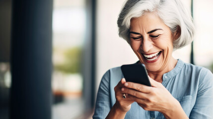 A senior woman looking at the smartphone and laughing closeup. - obrazy, fototapety, plakaty