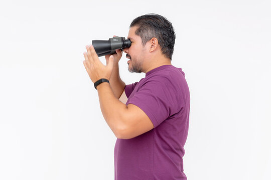 Side View Of A Focused Man Holding Binoculars, Searching Or Observing, Isolated On A White Background.