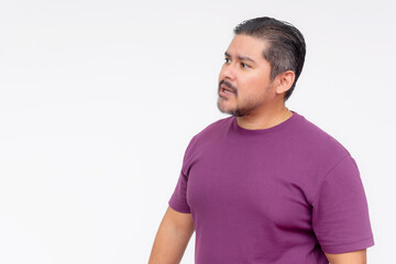 Studio portrait of a thoughtful middle-aged man in a purple shirt looking to the side against a white background.