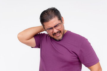 Obraz premium Middle-aged man in glasses exhibits neck pain, holding neck with a grimace of discomfort against a white backdrop.