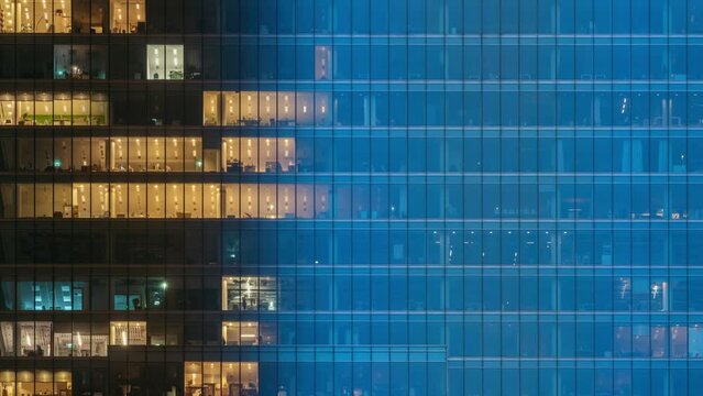 Day to night time-lapse timeslice effect blinking office windows lights, high-rise glass skyscraper business building in city downtown, work non-stop, turn on and off, endless work without breaks