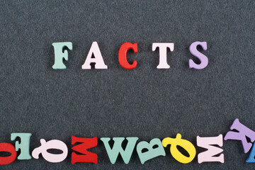 FACTS word on black board background composed from colorful abc alphabet block wooden letters, copy space for ad text. Learning english concept.