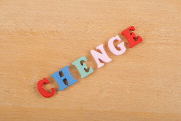 CHENGE word on wooden background composed from colorful abc alphabet block wooden letters, copy space for ad text. Learning english concept.