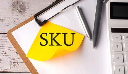 SKU word on a yellow sticky with calculator, pen and clipboard