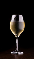 glass of white wine isolated on black background close-up