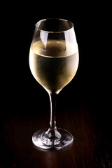 glass of white wine isolated on black background