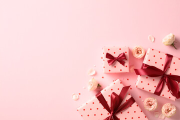 Saint Valentine day holiday background with pink gift boxes with red ribbon bow, roses buds, confetti on pastel pink background. Flat lay composition. Top view.